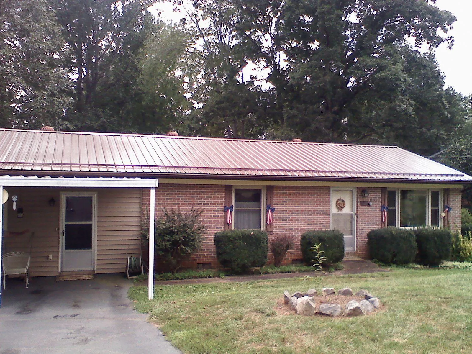 Bronze metal roof and carport on a brick ranch home — Roof Repair work by our crew in Sparrow Bush